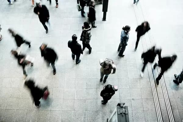 People crossing a station concourse, seen from above